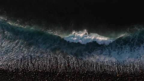 An aerial view of a wave in a pebble beach Stock Footage 150338458