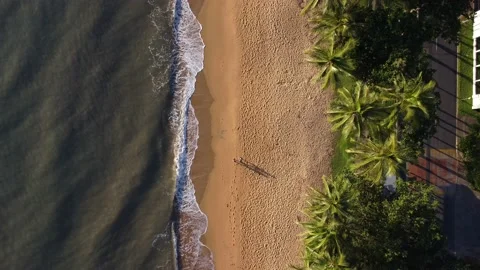 Aerial View Of Wave Reaching Sandy Coastline, Two People Walking Up The Beach Stock Footage 239574518