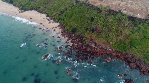 Aerial view. The waves are washed by a steep bank covered with palm trees. 스톡 동영상 104184371