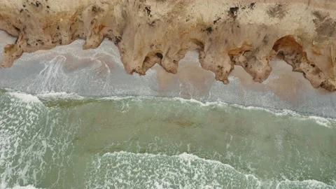 Aerial view of waves beating against a rocky shore on a sandy tropical beach. Stock Footage 156051465
