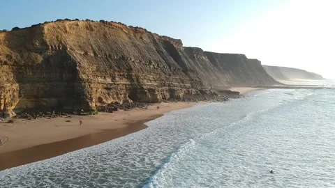 Aerial view of waves on a beautiful sandy ocean beach and cliff Stock Footage 134836597