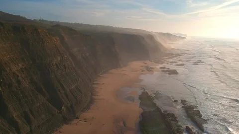 Aerial view of waves on a beautiful sandy ocean beach and cliff Stock Footage 143732969