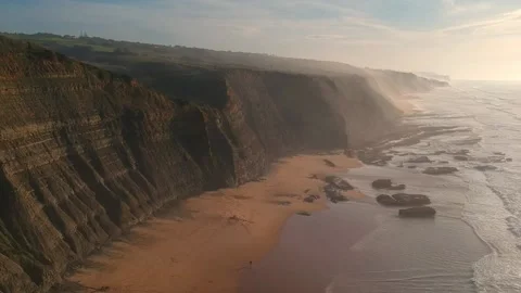 Aerial view of waves on a beautiful sandy ocean beach and cliff Stock Footage 143732991