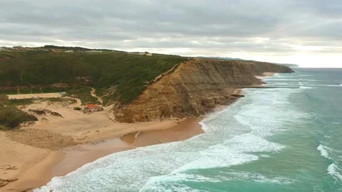 Aerial view of waves on a beautiful sandy ocean beach and cliff. Stock Footage 146282266