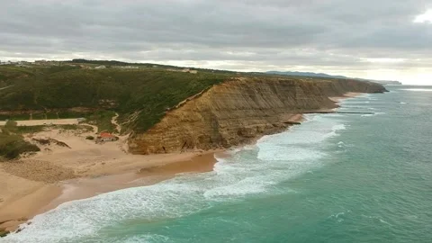 Aerial view of waves on a beautiful sandy ocean beach and cliff. Stock Footage 146282910