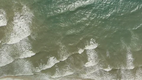 Aerial view waves break against the rocks on the beach in a storm Stock Footage 97459545