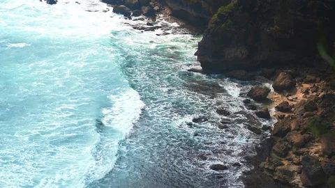 Aerial view waves break on dark rocks near beach Sea waves on the stones Stock Footage 119227507