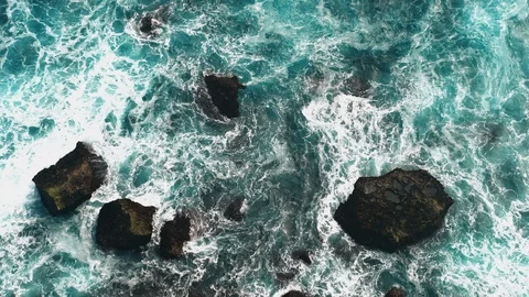 Aerial view waves break on dark rocks near beach Sea waves on the stones Stock Footage 119228598