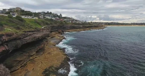 Aerial View Waves Break On rock cliffs At Sunset Stock Footage 70825137