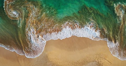 Aerial view waves break on white sand beach at sunset Stock Footage