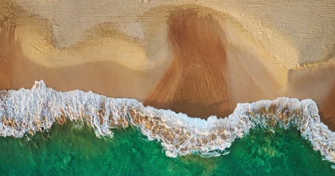 Aerial view waves break on white sand beach at sunset Stock Footage 63562489