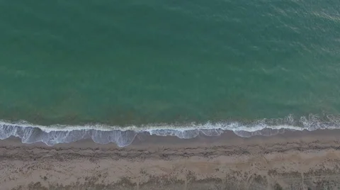 Aerial view waves break on white sand beach at sunset, land meets sea 스톡 동영상 68918605
