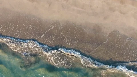 Aerial view waves break on white sand beach Stock Footage 84813579
