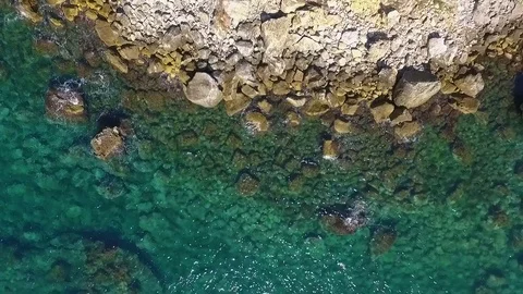 Aerial view of waves breaking against coastline rocks Stock Footage 83369509