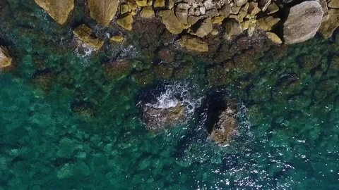 Aerial view of waves breaking against coastline rocks Stock Footage 83370618