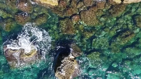 Aerial view of waves breaking against coastline rocks Stock Footage 83372972