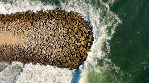 Aerial view of waves breaking into an artificial stone pier. Stock Footage 126208797