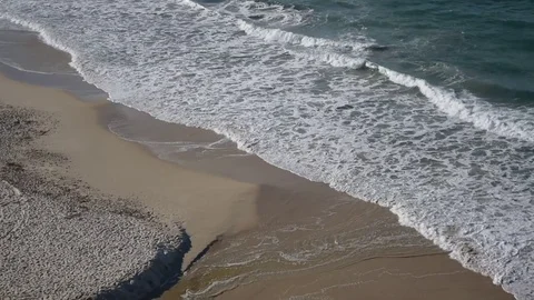 Aerial view of waves breaking onto the beach sand Stock Footage 77716033