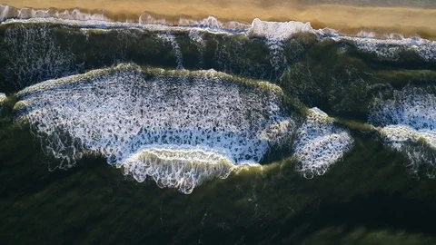 Aerial view of waves breaking on the beach 스톡 동영상 97857036