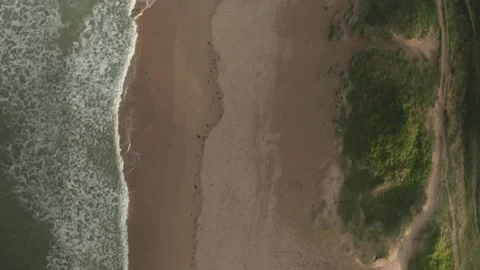 Aerial view of waves breaking on the beach in Cornwall, United Kingdom. Stock Footage 219545896