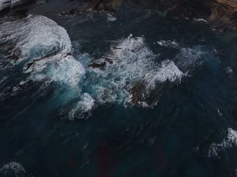 Aerial view. Waves breaking on beautiful volcanic rocks. Amoreira, Portugal Stock Footage 77285083