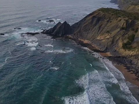 Aerial view. Waves breaking on beautiful volcanic rocks. Amoreira, Portugal Stock Footage 77285367