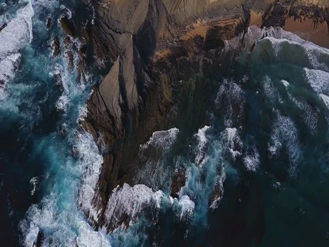 Aerial view. Waves breaking on beautiful volcanic rocks. Amoreira, Portugal Stock Footage 77285428
