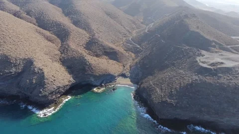 Aerial view of waves breaking over volcanic rocks on a hidden cove, Gran Canaria Stock Footage 346425967