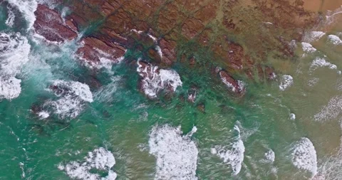 Aerial view of waves breaking on the rocks in the ocean Stock Footage 298217550