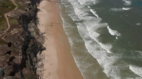 Aerial view of waves breaking on the shore of a Portuguese beach Stock Footage 170707590