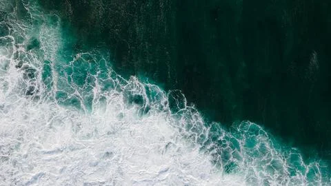 Aerial View of Waves Crashing Creating White Sea Foam Stock Photos