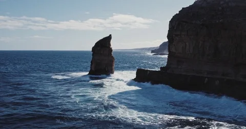 Aerial view of waves crashing on dramatic sea cliff coastline Stock Footage 77437465