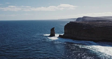 Aerial view of waves crashing on dramatic sea cliff coastline Stock Footage 77437723