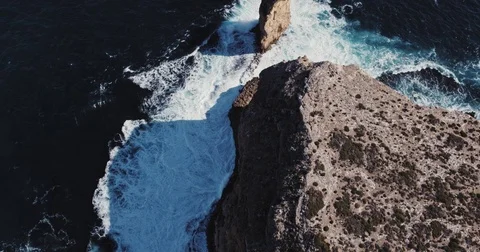 Aerial view of waves crashing on dramatic sea cliff coastline Stock Footage 77438586