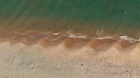 Aerial view of waves crashing on sandy beach. 4K Stock Footage 112154668