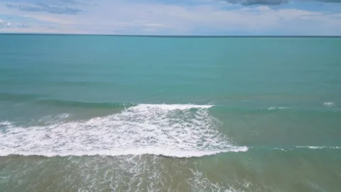 Aerial View of Waves Crashing on Sandy Beach and Open Sea 動画素材 339075711