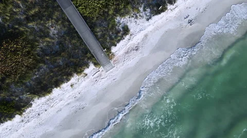 Aerial view of Waves Cresting on South Florida Beach with Boardwalk Stock Footage 167698847