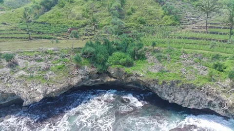 Aerial view of the waves hitting the rocks Stock Footage 239615939