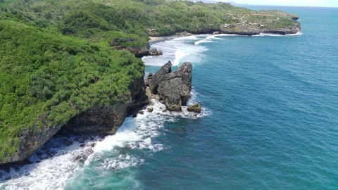Aerial view of the waves hitting the rocks Stock Footage 239616604