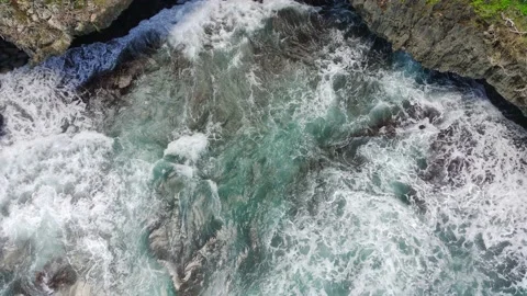 Aerial view of the waves hitting the rocks Stock Footage 239616666