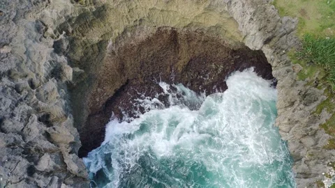 Aerial view of the waves hitting the rocks Stock Footage 239617769