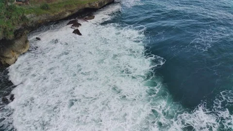 Aerial view of the waves hitting the rocks Stock Footage 239619638