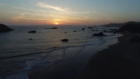 Aerial View of Waves Lapping and Person Walking on the Shore at Sunset Stock Footage 71160736