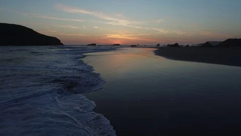 Aerial View of Waves Lapping and Birds Flying Along Shoreline at Sunset Stock Footage 71161501