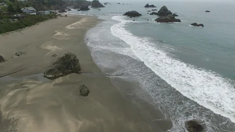 Aerial View of Waves Lapping Shore Along Coastal Town 스톡 동영상 71162969