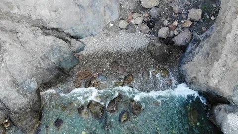 Aerial view waves roll on rocks and clear azure sea water Video stock 103182758