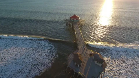 Aerial view of waves rolling by pier at sunset Stock Footage 157146558