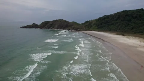 Aerial View of Waves on a Tropical Beach with Lush Green Hills Видео 336452555