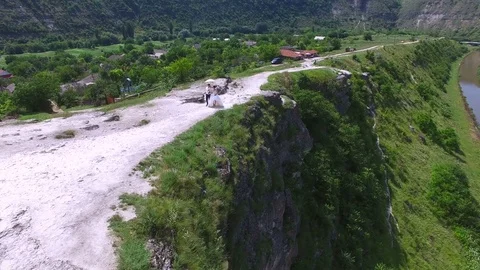 Aerial view of wedding couple having a walk on a cliff above river Stock Footage 71479310