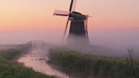 Aerial view of Wergea windmill surrounded by sunrise haze and fields Stock Footage 313152118